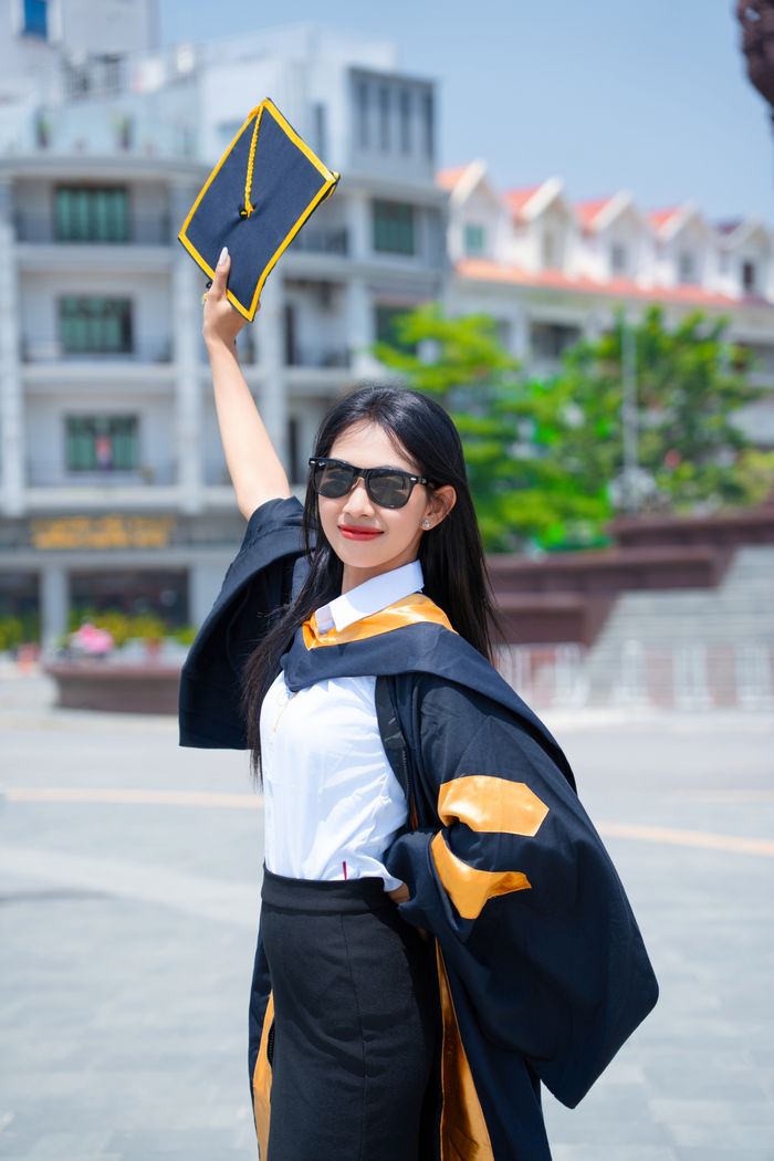 Joyful graduate celebrating achievement outdoors.